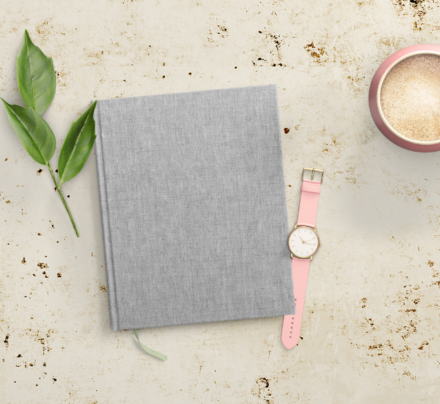 baner produktu w sklepie online zdjecie zamknietej ksiazki na marmurowym blacie obok rozowy zegarek listki i kawa