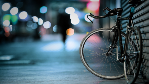 baner zdjecie rower oparty o sciane tlo wiczorem miasto jakies swiatla rozmyte